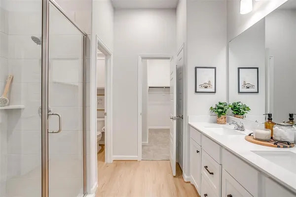 a bathroom with a granite countertop sink a mirror and shower