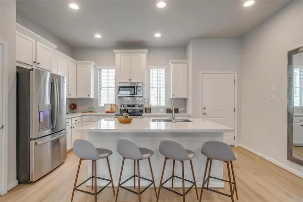 a kitchen with stainless steel appliances a refrigerator and a stove top oven