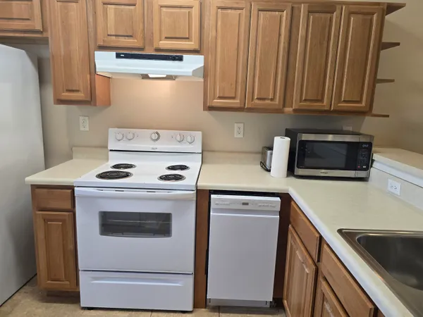 an empty room with a chandelier fan and windows