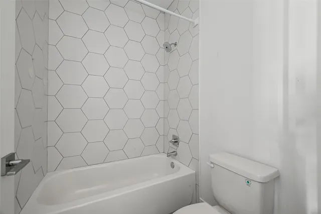a bathroom with a white bathtub and a toilet