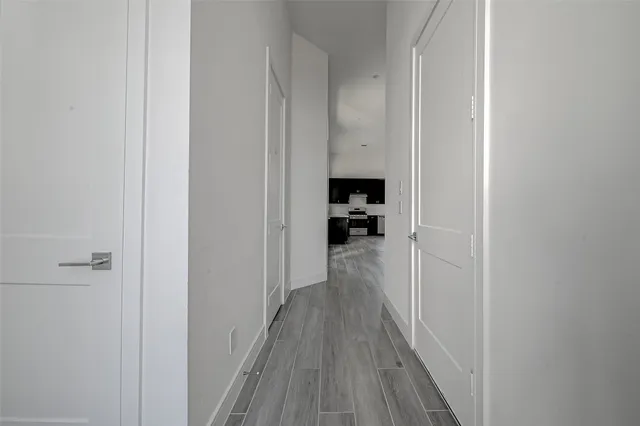 a view of a hallway with wooden floor and a living room