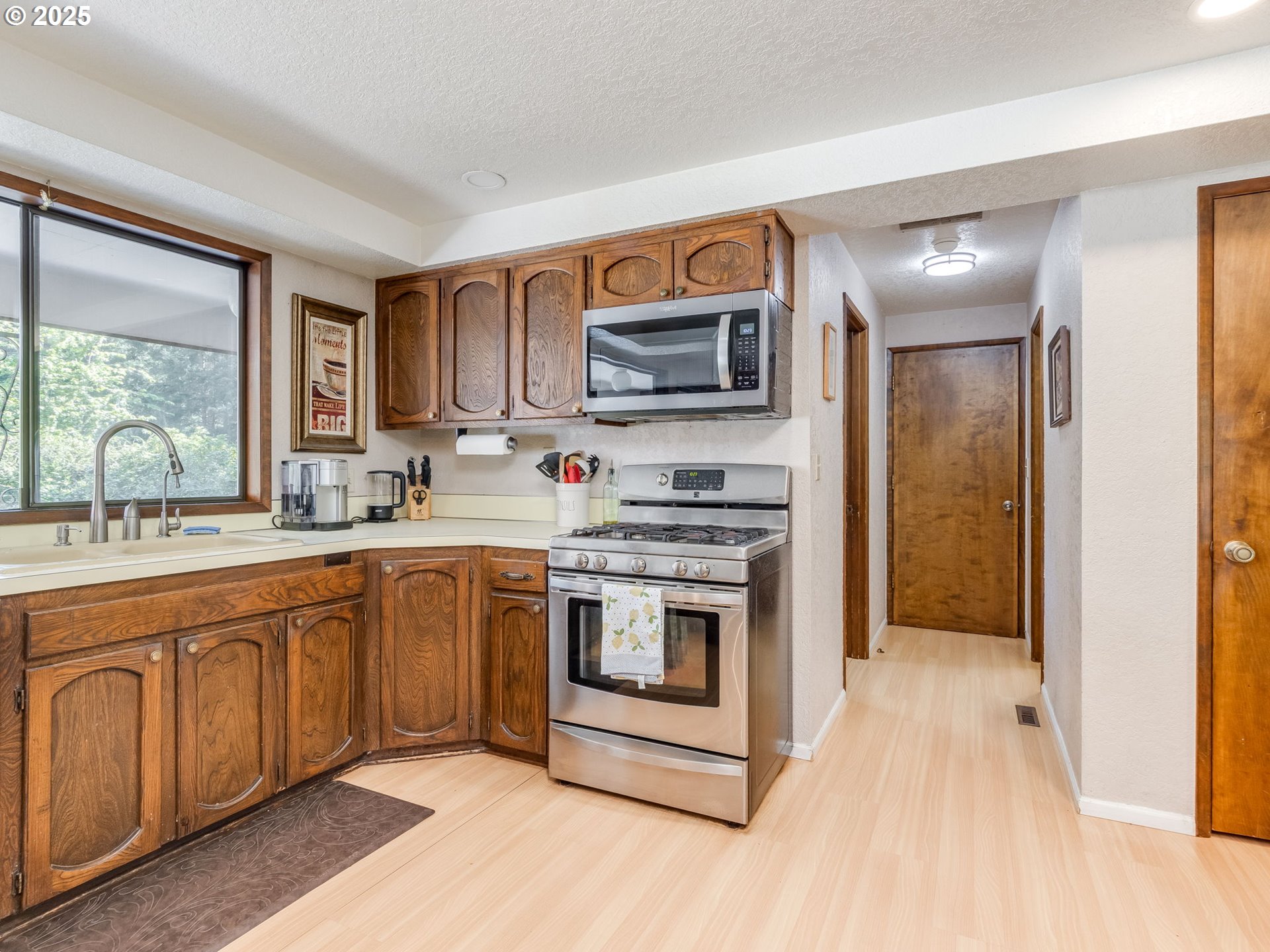11963 Broadacres Road Northeast Hubbard, OR 97032 - Photo 26 of 42 a kitchen with stainless steel appliances granite countertop a stove a sink and a microwave