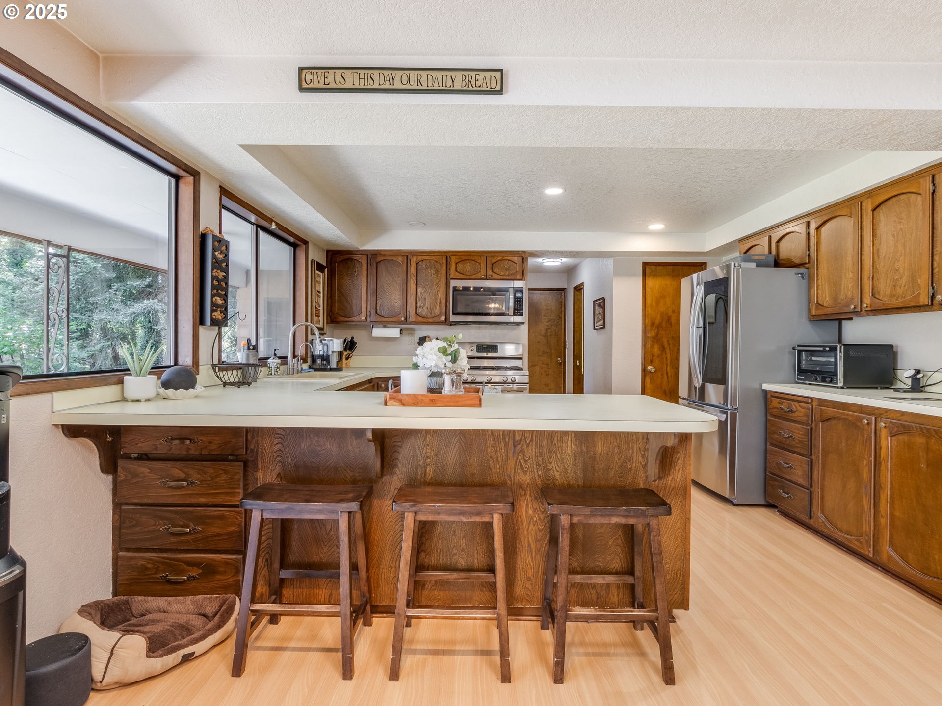 11963 Broadacres Road Northeast Hubbard, OR 97032 - Photo 28 of 42 a kitchen with stainless steel appliances granite countertop a table chairs sink refrigerator and cabinets
