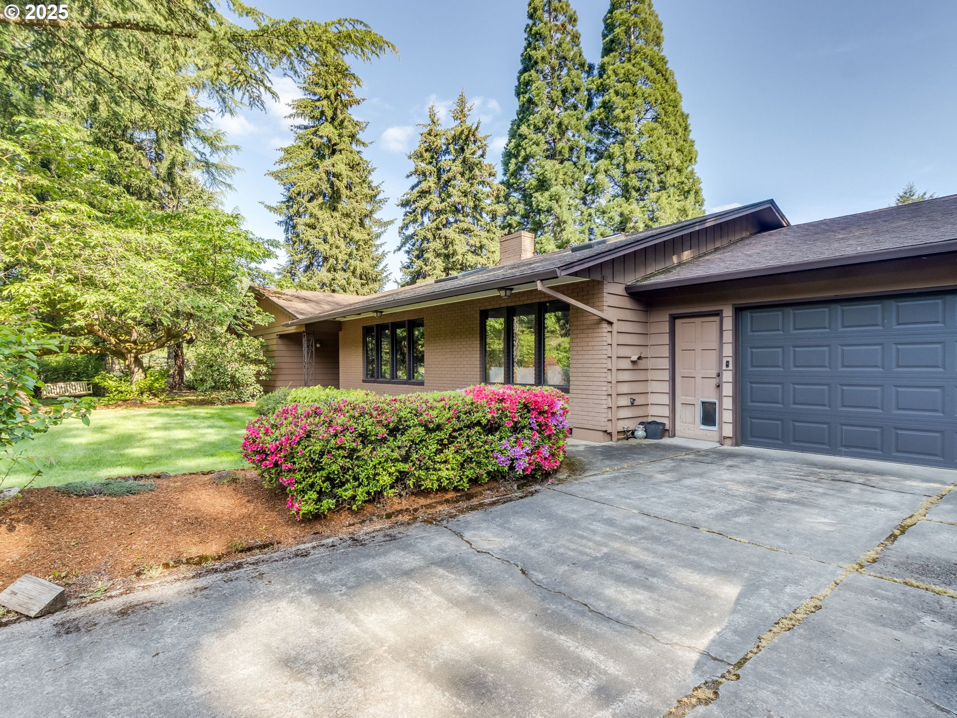 11963 Broadacres Road Northeast Hubbard, OR 97032 - Photo 3 of 42 a front view of a house with a garden