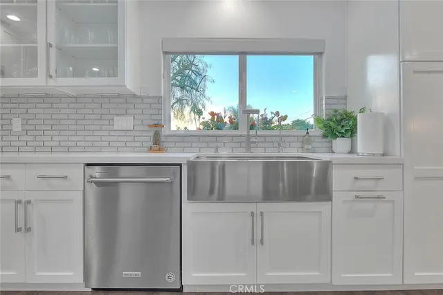 a kitchen with white cabinets and a window