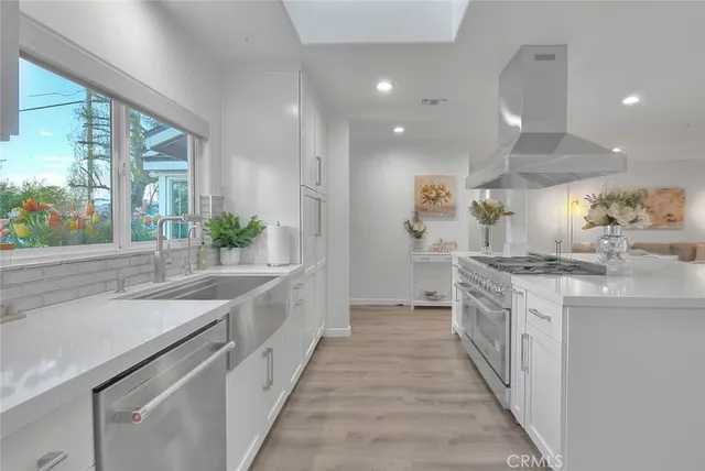 a large white kitchen with a large window