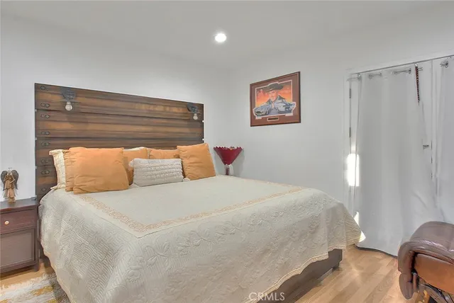 a bedroom with a bed and wooden floor