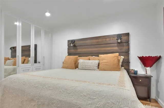 a bedroom with a large bed and a potted plant