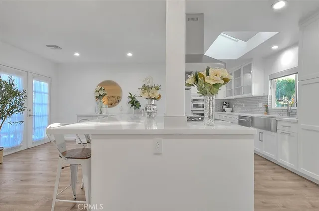 a kitchen with kitchen island stainless steel appliances a sink and living room view