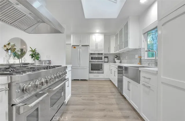 a large kitchen with stainless steel appliances granite countertop a stove and a sink