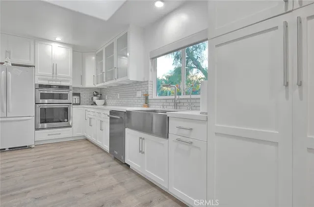 a kitchen with white cabinets and white appliances