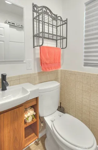 a white toilet sitting next to a bathroom sink and vanity