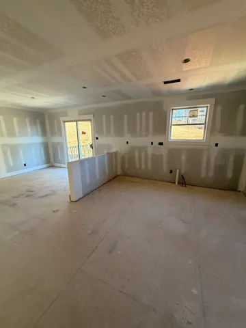 an empty room with windows and cabinet