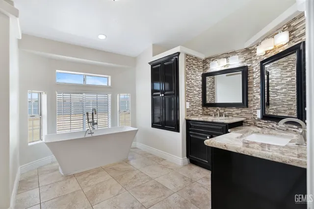 a spacious bathroom with a tub sink and mirror