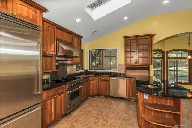 a kitchen with stainless steel appliances granite countertop a stove a sink and a refrigerator