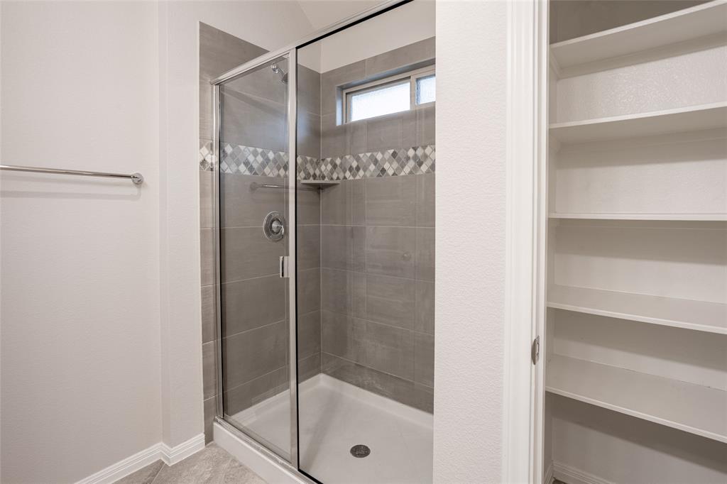 615 Stampede Road San Marcos, TX 78666 - Photo 8 of 26 A well-appointed shower with modern tile work and convenient storage solutions awaits.