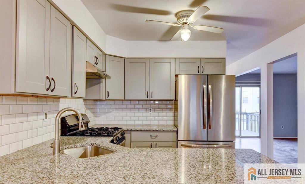 a kitchen with stainless steel appliances granite countertop a sink a refrigerator and a cabinets