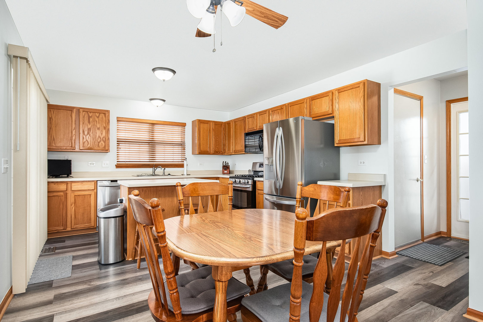 7211 Faxton Lane Plainfield, IL 60586 - Photo 3 of 21 a kitchen with stainless steel appliances granite countertop a dining table and chairs