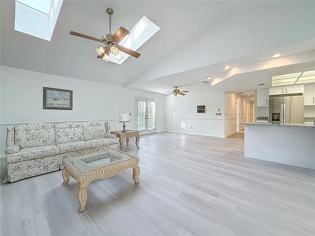 a bedroom with a bed ceiling fan and a wooden floor
