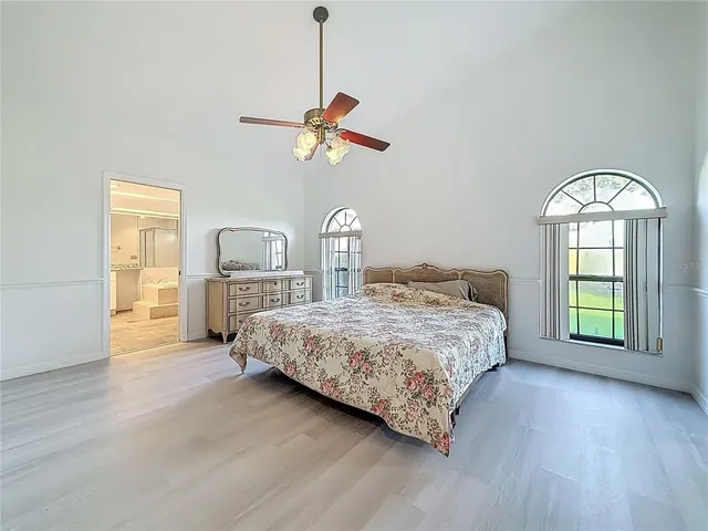 a bed sitting in a spacious bedroom next to a window