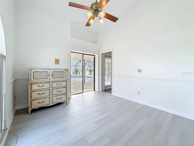 a view of an empty room with wooden floor and cabinets