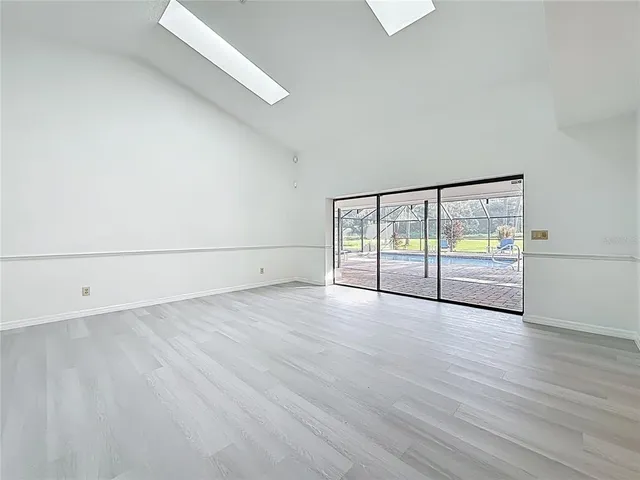 an empty room with wooden floor and mirror
