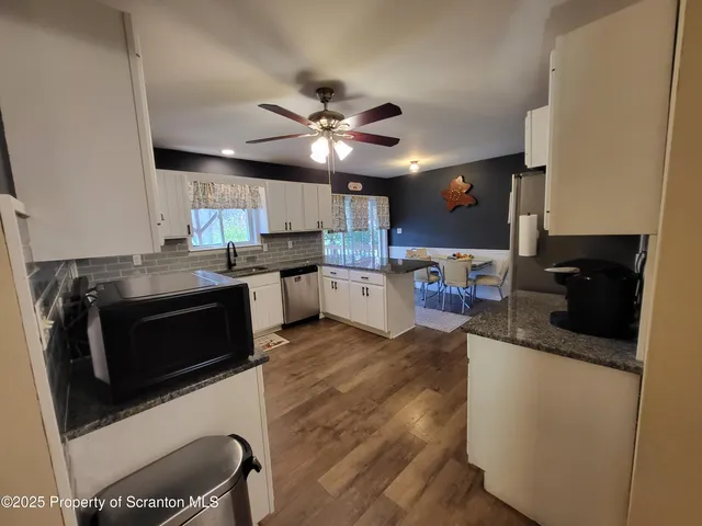 a kitchen with granite countertop a refrigerator and a stove top oven