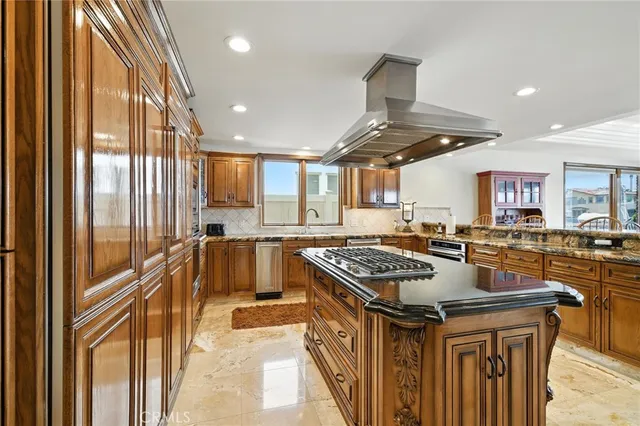 a kitchen with kitchen island granite countertop a stove and a sink