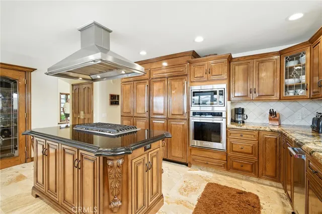 a kitchen with stainless steel appliances granite countertop a stove a sink dishwasher and cabinets with wooden floor