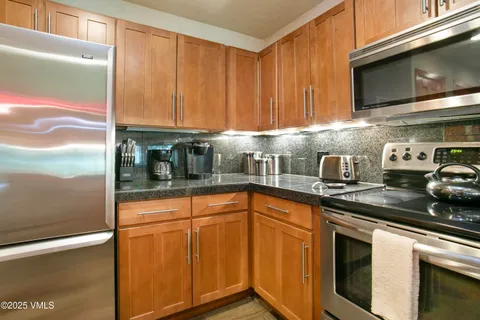 a kitchen with stainless steel appliances granite countertop a sink a stove microwave and cabinets