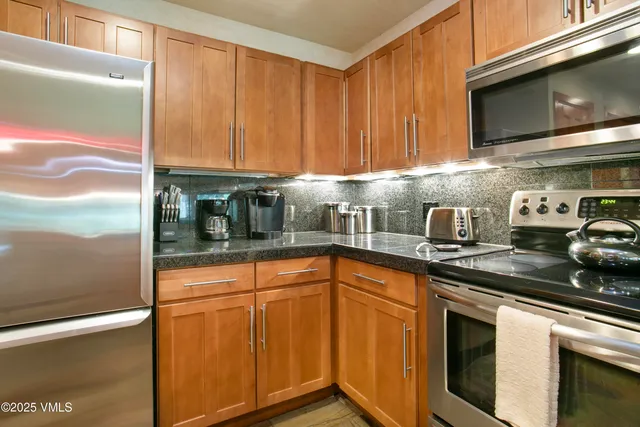 a kitchen with stainless steel appliances granite countertop a sink a stove microwave and cabinets