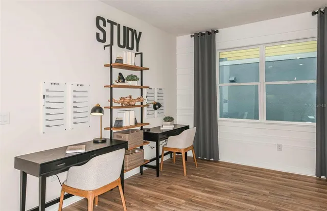 a view of a workspace with furniture and a window