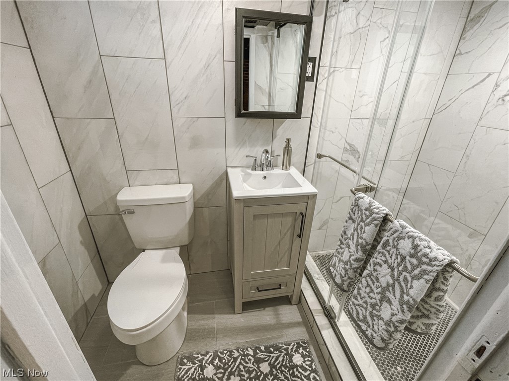 24709 Emery Road Warrensville Heights, OH 44128 - Photo 22 of 34 Bathroom featuring vanity, toilet, tile walls, and tile flooring