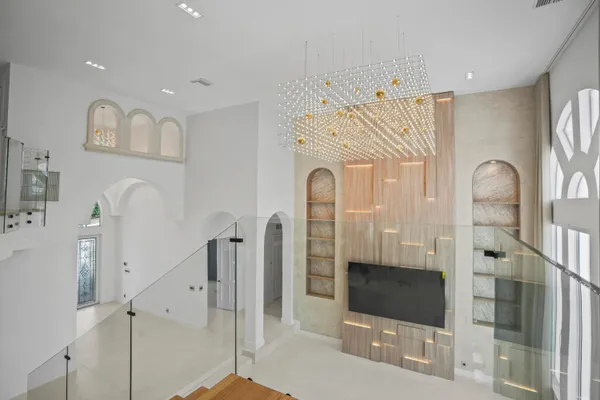 a living room with furniture a flat screen tv and a floor to ceiling window