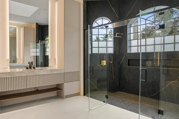 a bedroom with a bed television on desk and a window