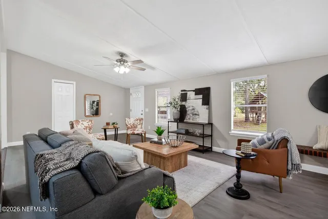 a kitchen with granite countertop stainless steel appliances white cabinets and a window