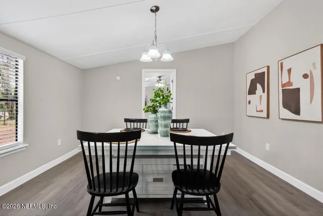 a kitchen with stainless steel appliances granite countertop a table chairs sink and cabinets