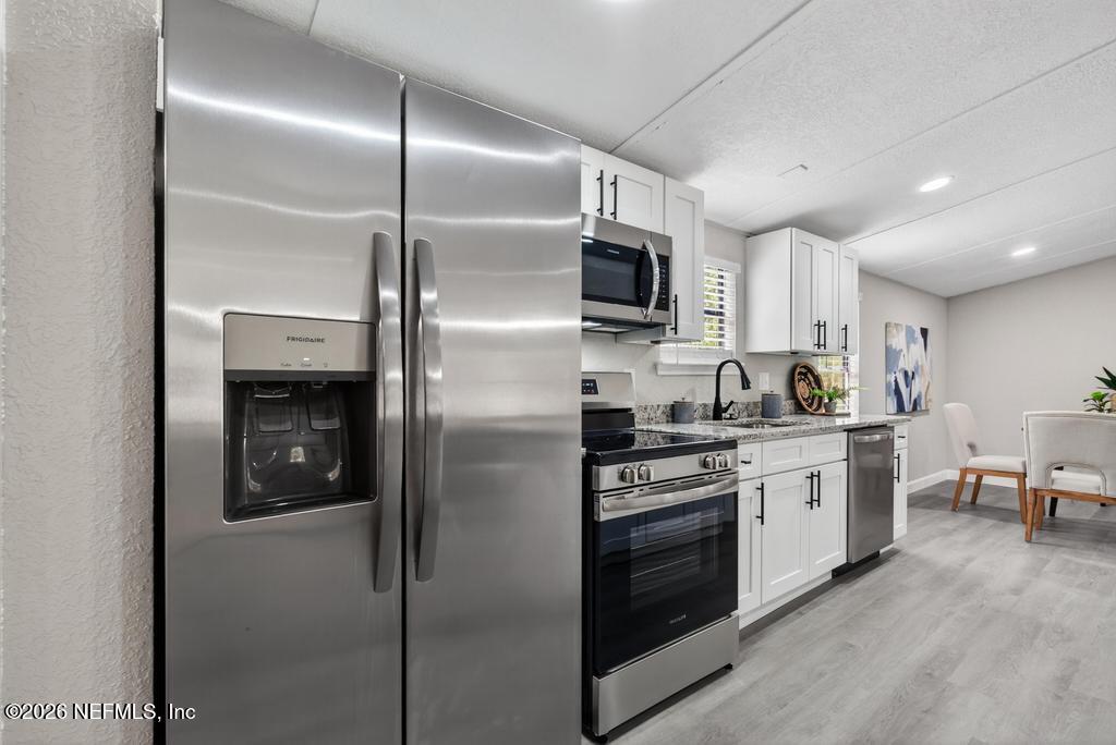95422 Plum Loop Fernandina Beach, FL 32034 - Photo 28 of 84 a kitchen with cabinets stainless steel appliances and a counter top space