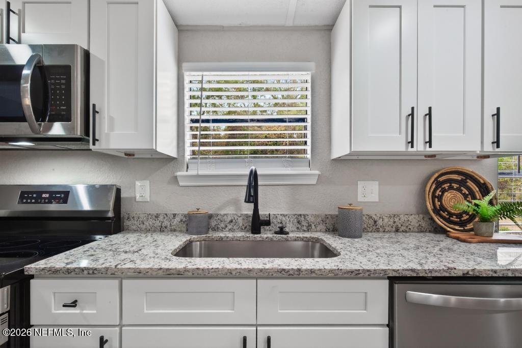 95422 Plum Loop Fernandina Beach, FL 32034 - Photo 32 of 84 a kitchen with granite countertop stainless steel appliances white cabinets and a window