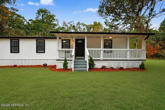 a view of house that has a big yard