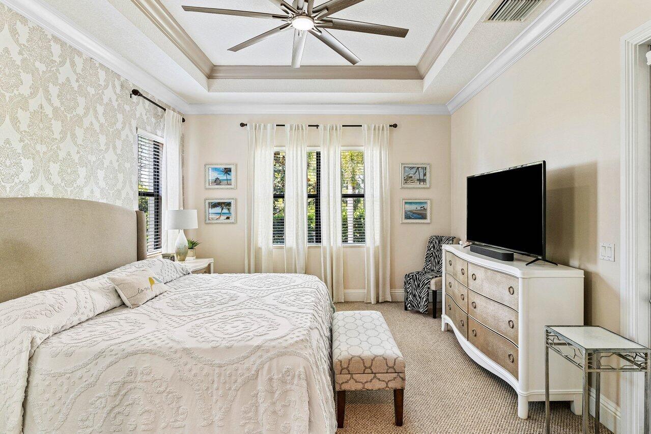 183 Calmo Circle Port St. Lucie, FL 34984 - Photo 17 of 38 a bedroom with a bed and a flat tv screen on dresser