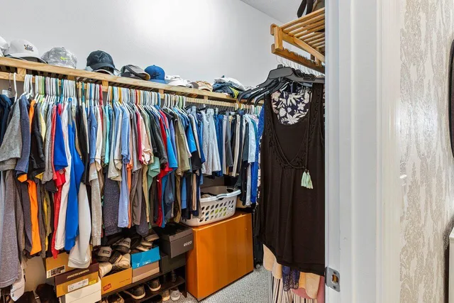 a view of walk in closet with clothes