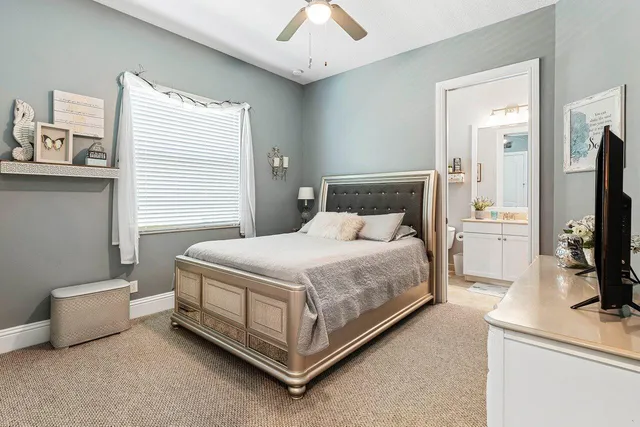 a bedroom with a bed and a flat tv screen on dresser
