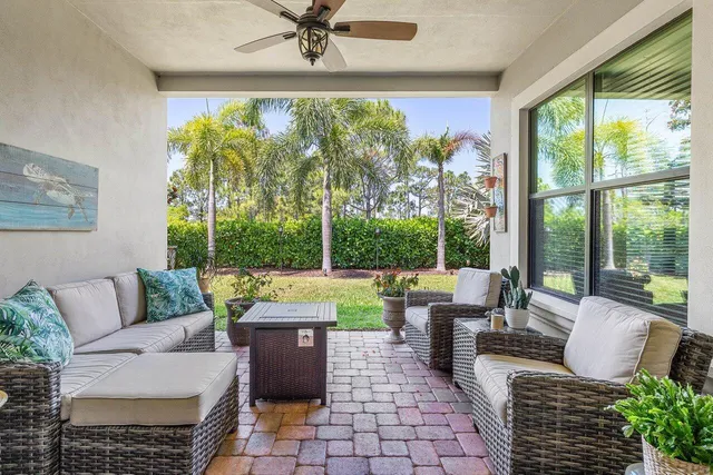 a living room with patio furniture and a floor to ceiling window