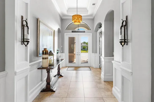 a living room with furniture a fireplace and a chandelier