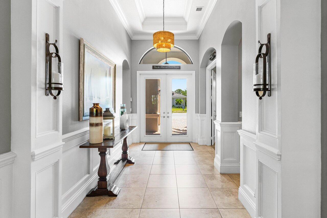 183 Calmo Circle Port St. Lucie, FL 34984 - Photo 4 of 38 a living room with furniture a fireplace and a chandelier