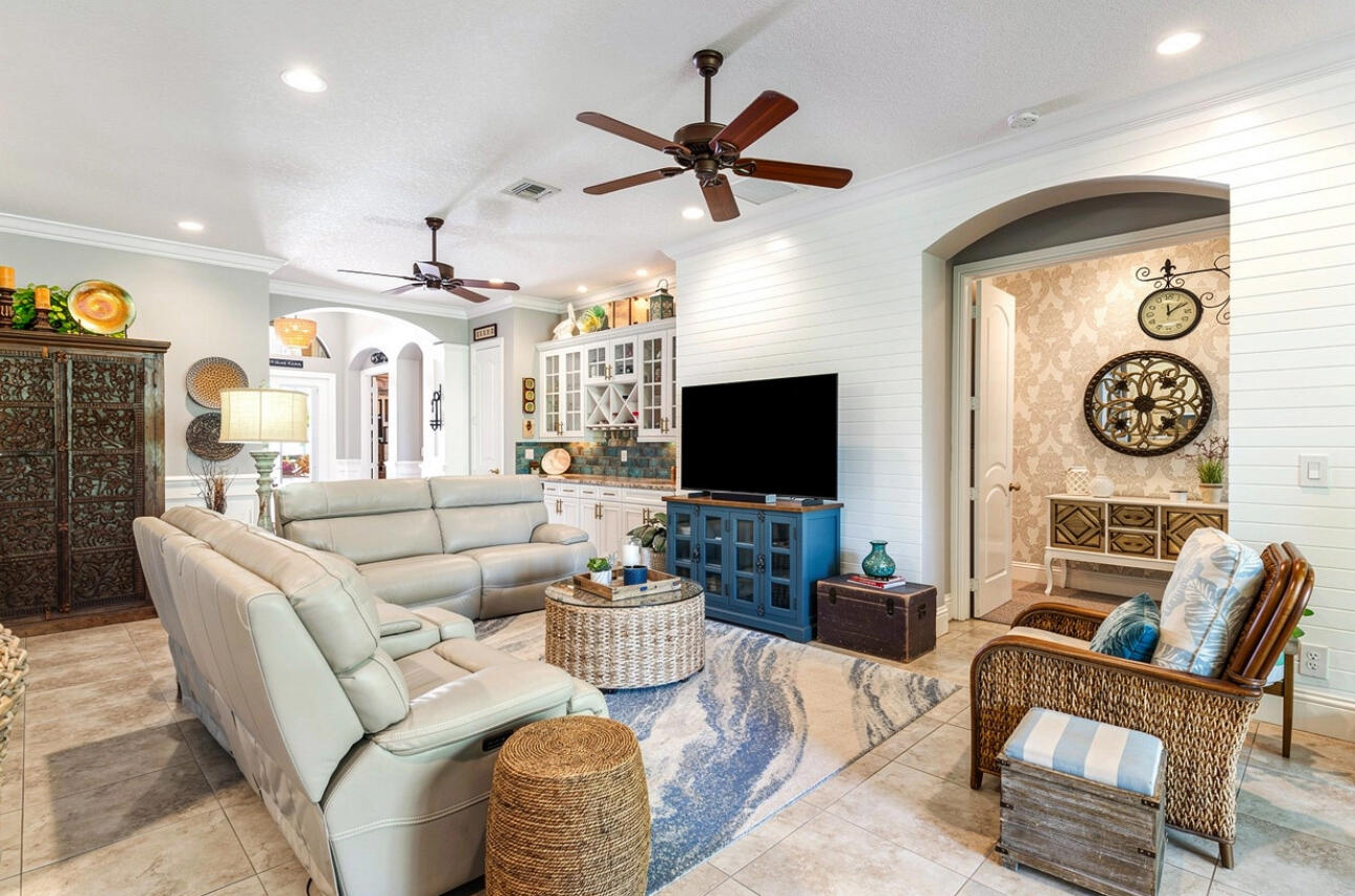 183 Calmo Circle Port St. Lucie, FL 34984 - Photo 5 of 38 a living room with furniture a clock and a flat screen tv