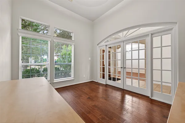a view of an empty room with a window and wooden floor