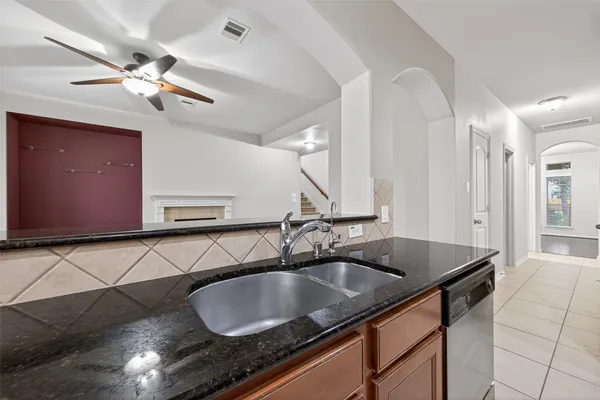 a kitchen with granite countertop a sink a counter top space and cabinets