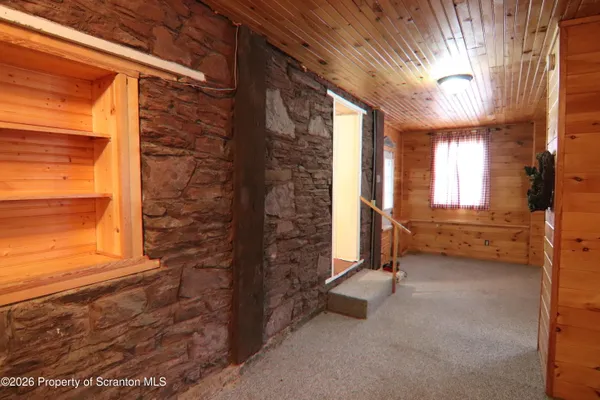 a view of an empty room with a fireplace and a window